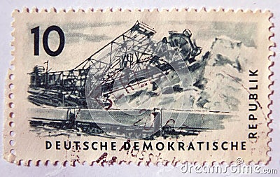 An old blue east german postage stamp with image of railway wagons and a mining activity Editorial Stock Photo