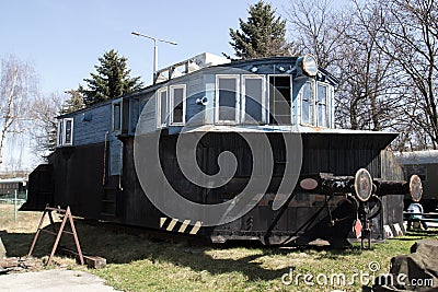 Old blue locomotive standing on the rails on the background of blue sky Stock Photo