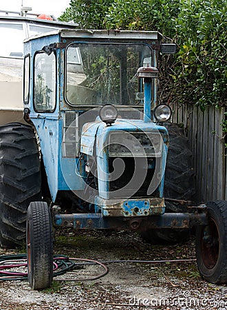 An old blue tractor full of rust parked somewhere in the South Island in New Zealand Stock Photo