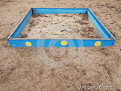 Old blue wooden sandbox in abandoned kindergarten with dirty sand Stock Photo