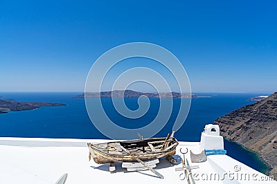 Old boat for decoration on a white roof. Santorini island, Greece Stock Photo
