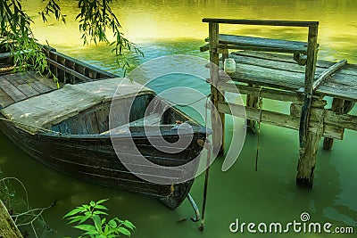 An old boat and a simple wooden pier from old boards Stock Photo