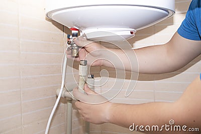 Old boiler is broken, repair and installation of a new water heater. Hired mechanic eliminates breakdown Stock Photo