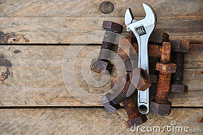 Old bolts with adjustable wrench tools on wooden background Stock Photo