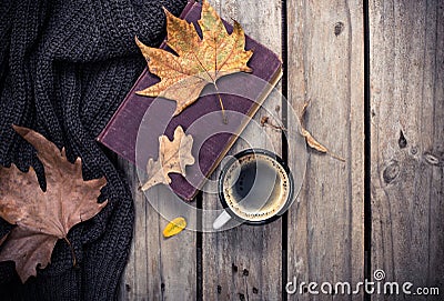 Old book, knitted sweater with autumn leaves and coffee mug Stock Photo