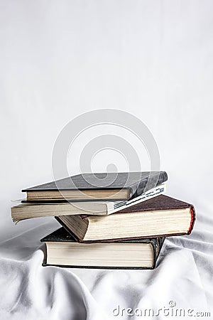 Old 4 books on white textured curtain with white background. Stock Photo