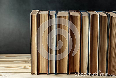 Old books on wooden shelf on dark background. Collection of vintage literature. Education and learning Stock Photo