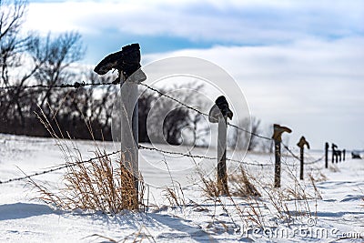 Old Boots on top of a Fence Line in the Snow Stock Photo