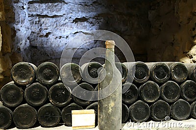 Old bottle of wine in the cellar of the winery Ancient wine bottles in the cellar WineryRed wine of ancient times Stock Photo