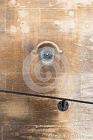Old brass doorbell button on a beige stone wall Stock Photo