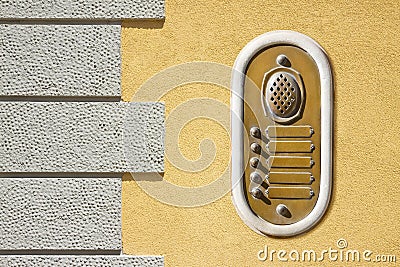 Old brass doorbell system with blank name tags against a new plaster wall at the entrance of an old building Stock Photo