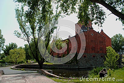 The old brick castle surrounded by green park Stock Photo