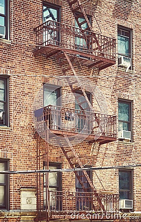 Old brick house building with iron fire escape, color toned picture, New York City, USA Stock Photo