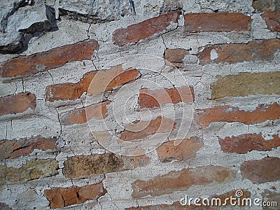 Old brick. The restored wall of the building of Roman times. Sunlight and warm brown-red shades of uneven bricks. Archaeological Stock Photo