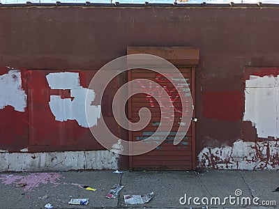 Old brick Wall with metallic roller shutter door. Abandoned industrial area Stock Photo