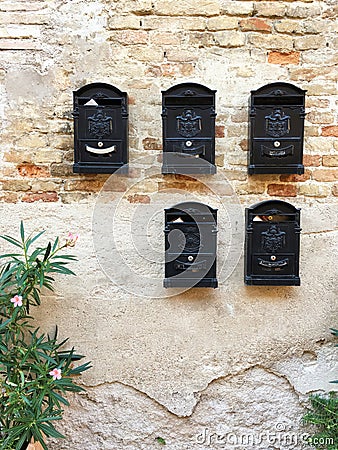 Old bricks wall with ancient post boxes, Italy Stock Photo