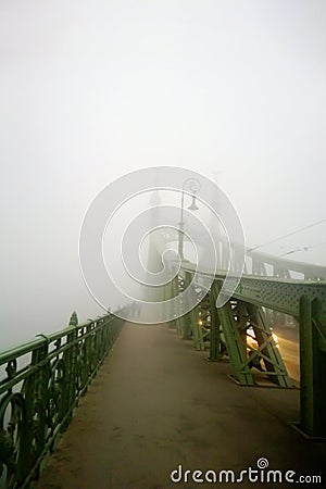 Old bridge in the fog. Mystical vision. A couple of people walk together in the fog. Stock Photo