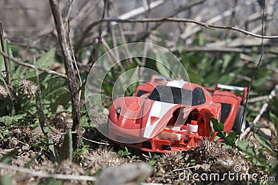 old broken children's toy sports car lies in the grass Stock Photo