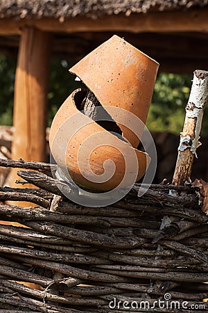 Old broken clay pot close up at wattle fence. Rural scene. Stock Photo