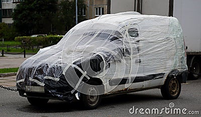 An old broken down car is wrapped in plastic wrap Stock Photo