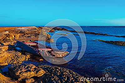 Old broken fishing boat on the shore Stock Photo