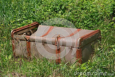 An old broken suitcase in the grass Stock Photo