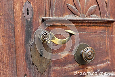 Old bronze door handle on the decorated wooden door Stock Photo