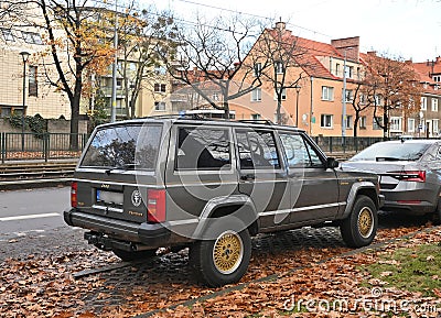 Old brown grey veteran offroad 4x4 retro Jeep Grand Cherokee high suspension parked Editorial Stock Photo