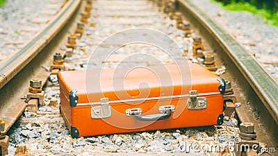 Old brown suitcase on the railway Stock Photo