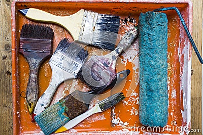 Old brushes on the painting tray Stock Photo