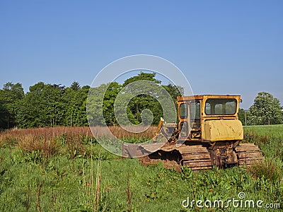 An Old Bulldozer in a Farm Field near Letham in Angus, Scotland, Its yellow Cabin rusted with age. Editorial Stock Photo