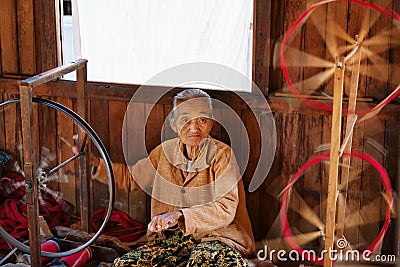 Old Burmese woman spinning yarn by hands Editorial Stock Photo