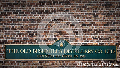 The Old Bushmills Distillery Co. Ltd Licensed to distil in 1608 sign on rustic brick wall Editorial Stock Photo