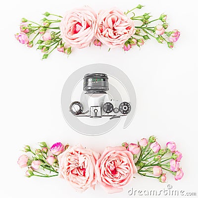 Old camera and roses, buds and leaves on white background. Flat lay, top view. Retro background. Stock Photo