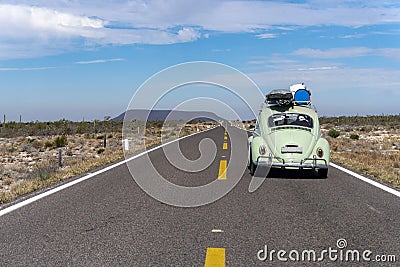 Old car on endless road from brazil to alaska Editorial Stock Photo