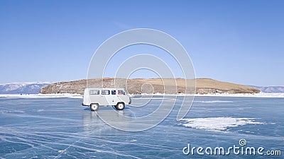 The old car moves on the ice of lake Baikal during the tour. A winter journey in Russia Stock Photo