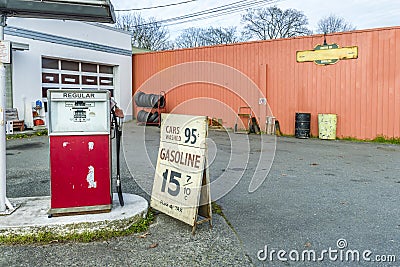 Old car repair shop with a gas station, advertising for cheap ga Stock Photo