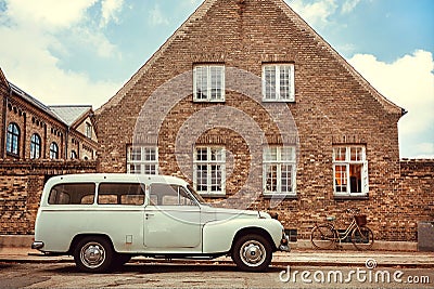 Old car on street with historical brick house. Vintage auto parked in city area Editorial Stock Photo