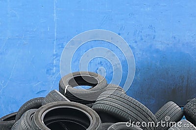 An old car tires stacked on blue background in a pile in area a car workshop, disposal recycling concepts Stock Photo