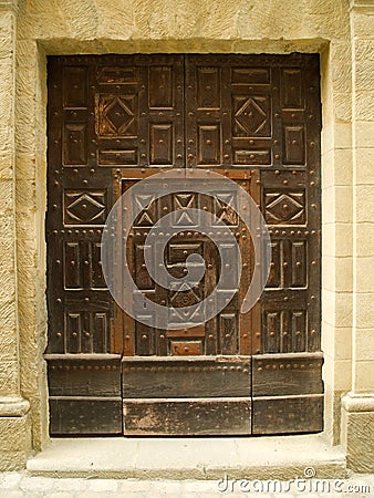Old carved door in stone wall Stock Photo