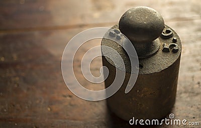Old counterweight for scale on wooden table Stock Photo