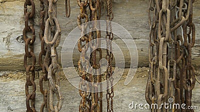 Old chains hang on a wooden log wall Stock Photo