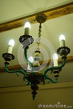 Old chandelier with five lamps hangs on the ceiling with a pre-revolutionary house. Stock Photo