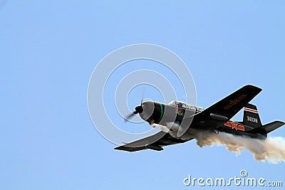 Old Chinese fighter plane flying and smoking Editorial Stock Photo