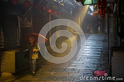 An old Chinese lady with an umbrella in a mysterious back alley and staircase in the Taiwanese village of Jiufen Editorial Stock Photo