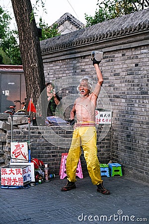 An old Chinese Kungfu master performs show on the street in Beijing, China Editorial Stock Photo