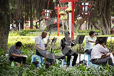 Old chinese people meet friends and sing song with playing classic musical instruments concert in park at Guangdong, China Editorial Stock Photo