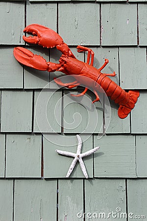 Old clapboard shingles on home`s exterior with lobster and starfish decorations Stock Photo