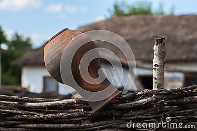 Old clay Jug on a wicker fence, rustic style, rural scenery Stock Photo