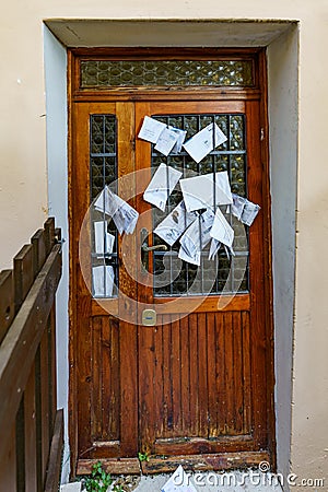 Old closed door to an abandoned house where the founding is being taken by the addressee of the letter Stock Photo